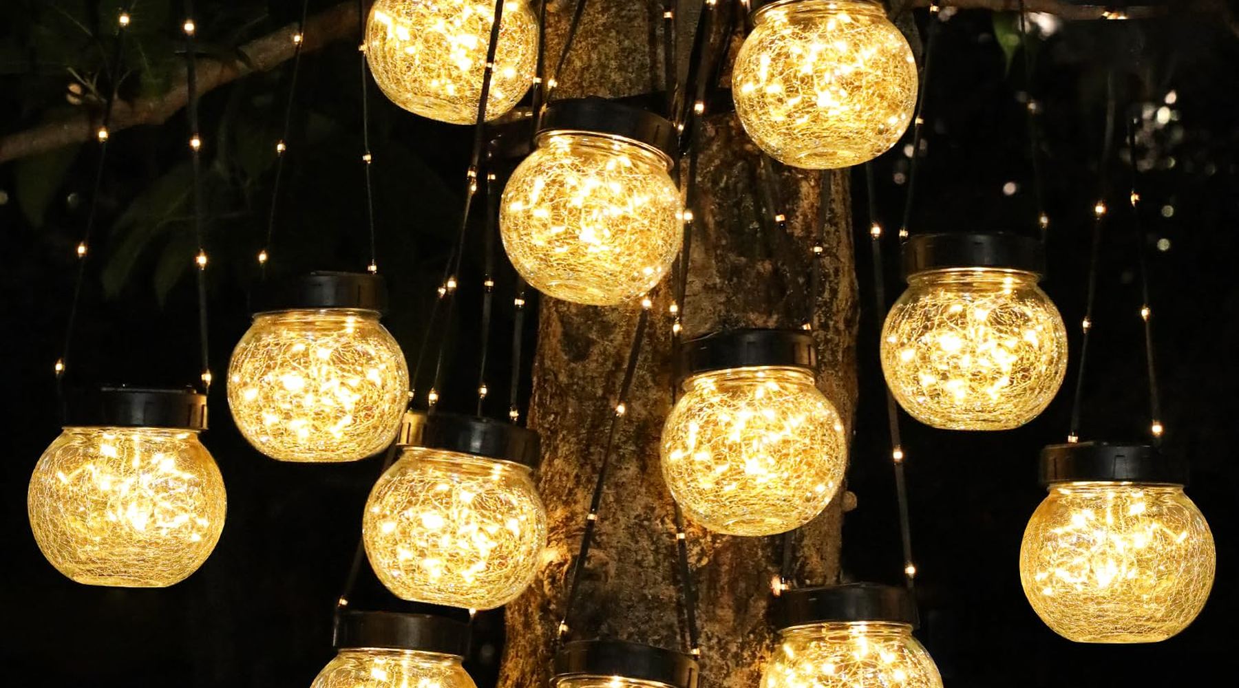 Solar hanging lanterns glowing in a garden at night